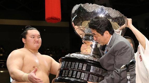 El Primer Ministro japonés Shinzo Abe entregando uno de los trofeos a Hakuho